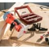 A 510W red milling machine on wood, surrounded by router bits and a small red screw case.