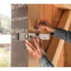 Someone uses a spirit level to check alignment on wood, holding a pencil with replaceable 2.8 mm HB lead for marking.
