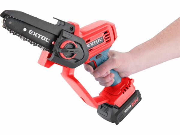 A hand holding a red and black cordless chainsaw with a battery pack.