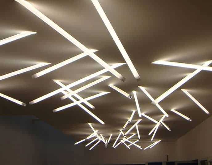 Overlapping linear LED lights on ceiling create a modern, abstract design.