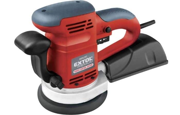 Red and black electric orbital sander with side handle and attached dust collection box.